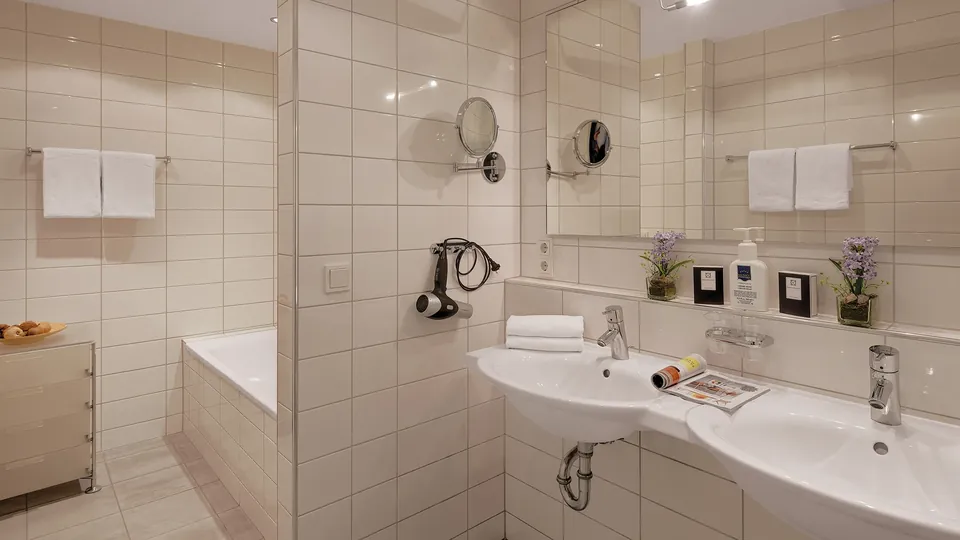 Elegantes Badezimmer der Suite mit freistehender Badewanne und Marmorfliesen - pure Entspannung